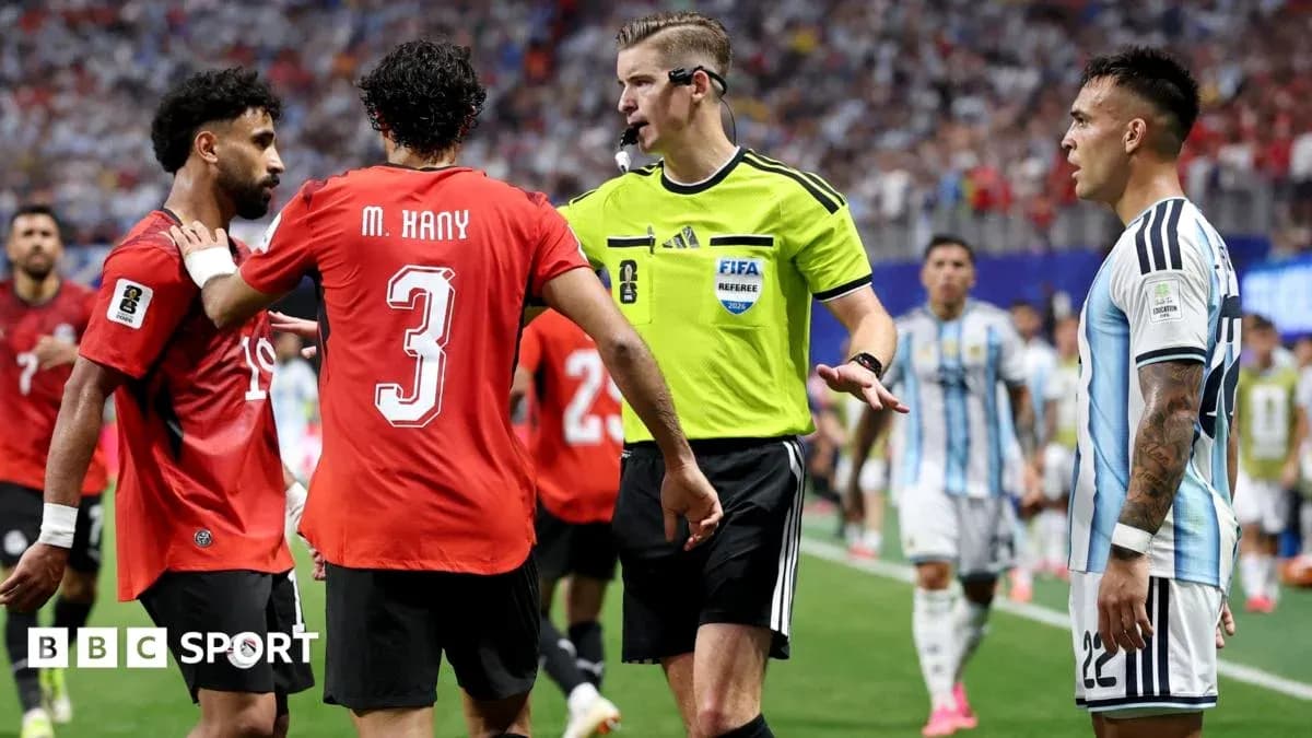 Joueurs et arbitre discutant sur le terrain de football
