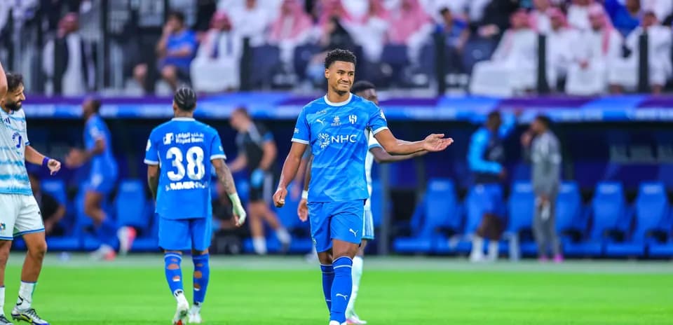 Joueur en bleu discutant pendant un match de football