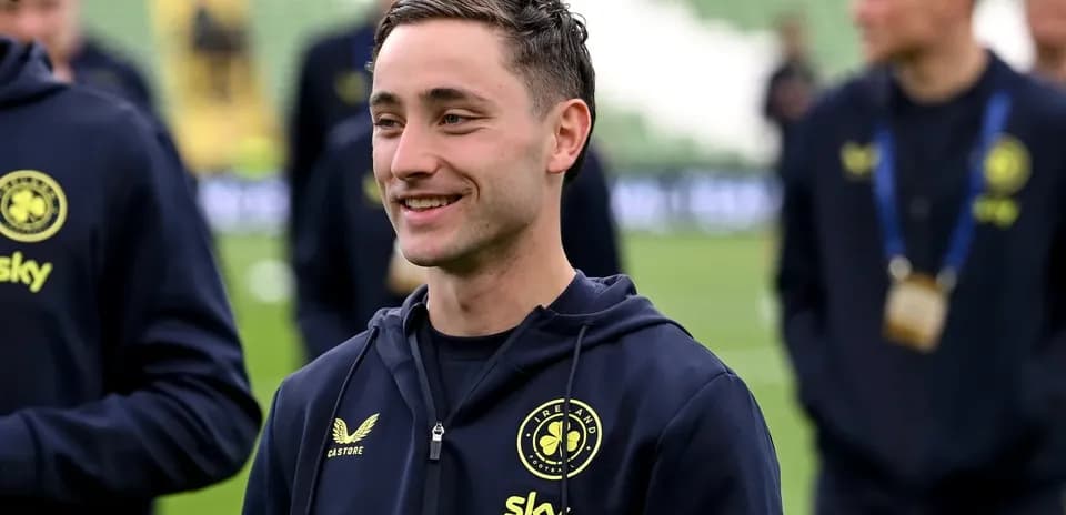 Joueur souriant en tenue d'équipe sur le terrain