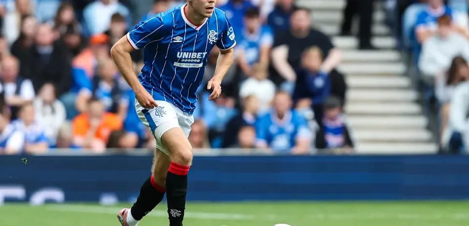 Joueur de Rangers courant avec le ballon sur le terrain
