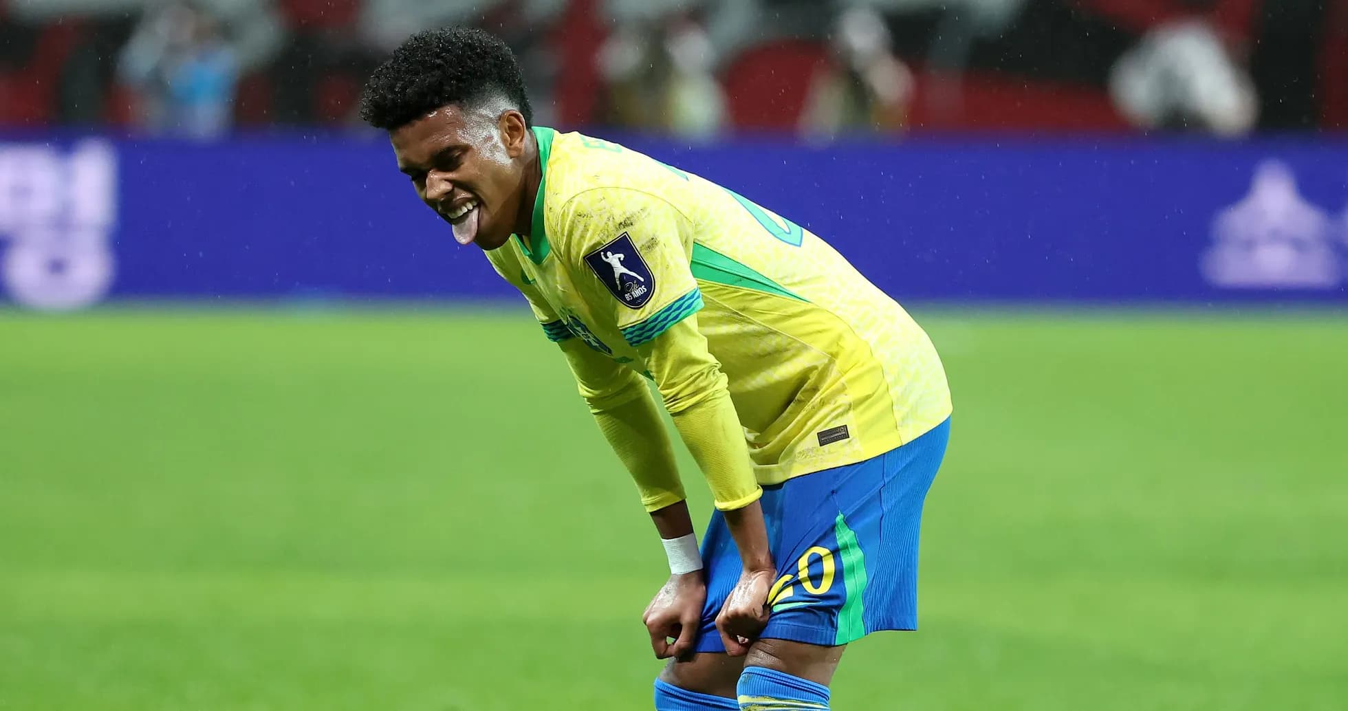 Joueur brésilien se tenant les genoux sur le terrain