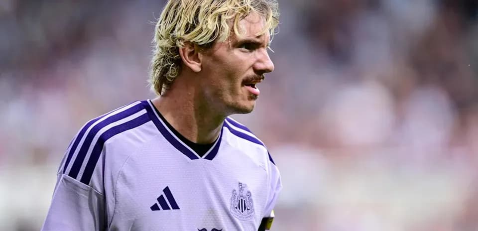Joueur de Newcastle en maillot violet sur le terrain