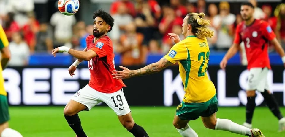 Joueur égyptien dribblant un adversaire australien