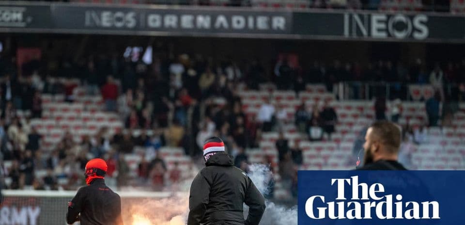 Supporters lighting flares in stadium during match