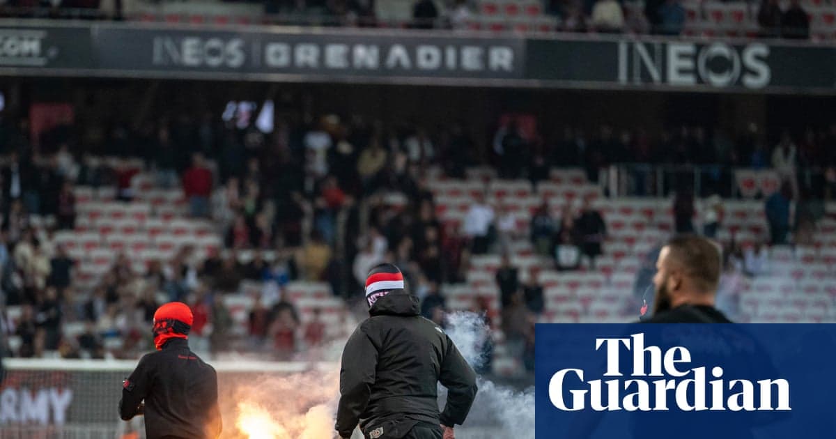 Supporters lighting flares in stadium during match