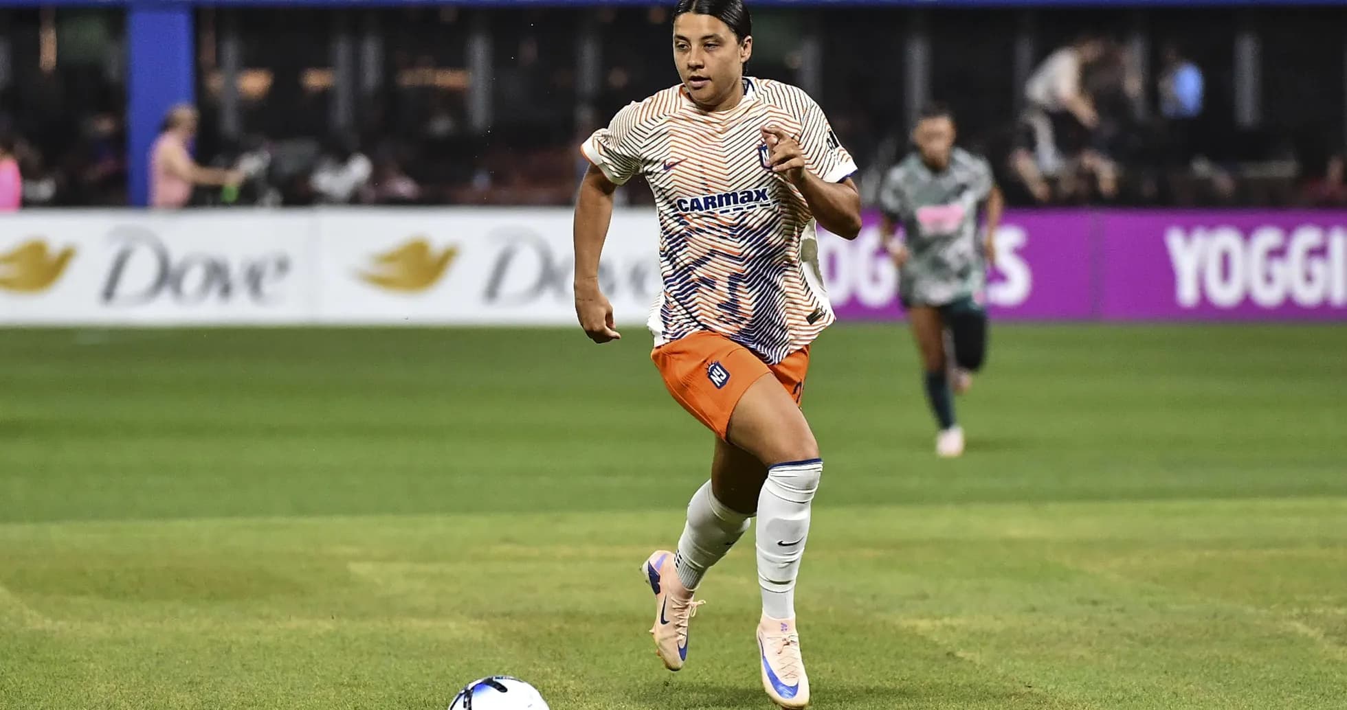 Joueuse courant avec le ballon sur le terrain