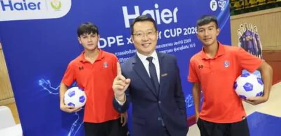 Trois personnes posant avec un ballon de football