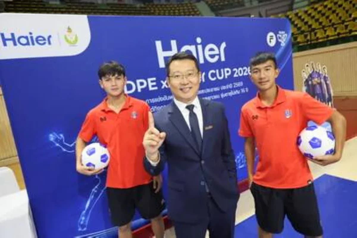 Trois personnes posant avec un ballon de football