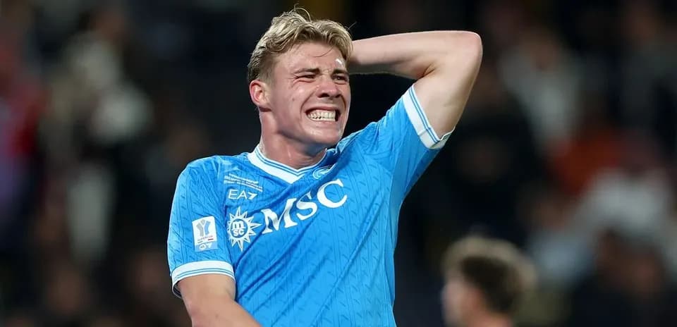 Joueur de football en maillot bleu se tenant la tête