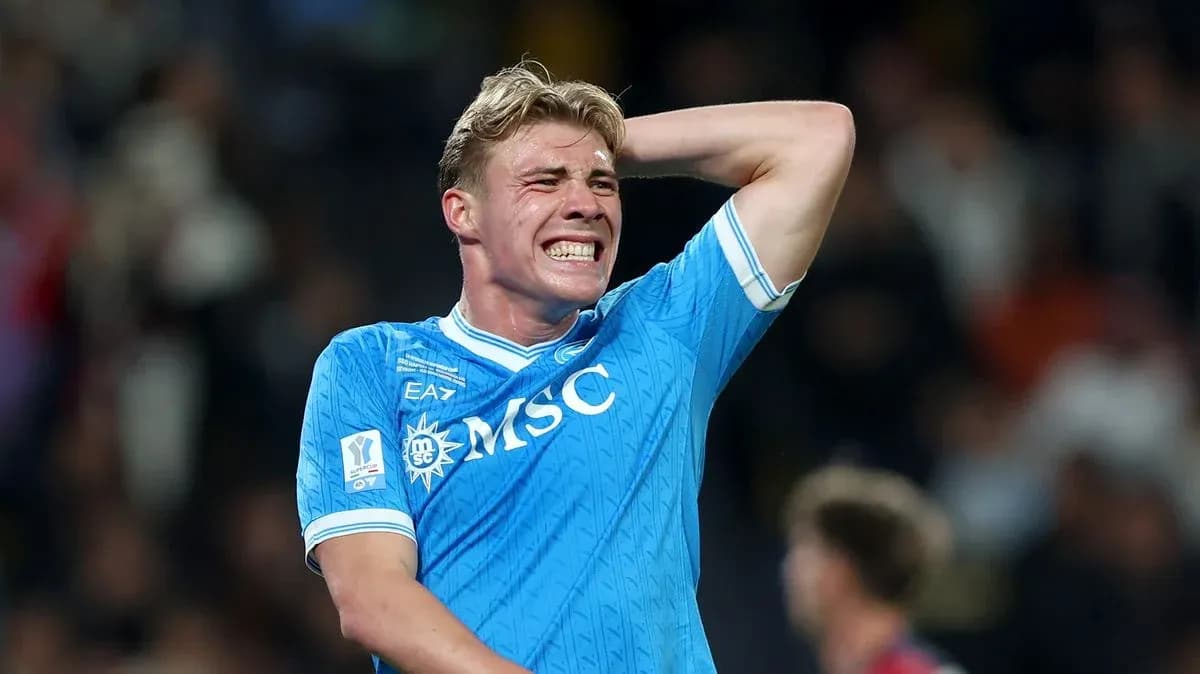 Joueur de football en maillot bleu se tenant la tête