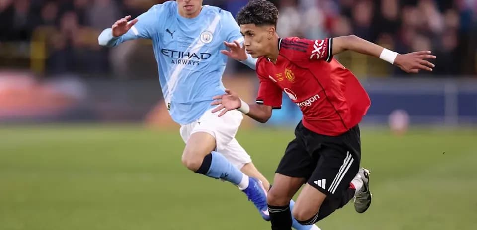 Joueur de Manchester United dribblant un adversaire de Manchester City