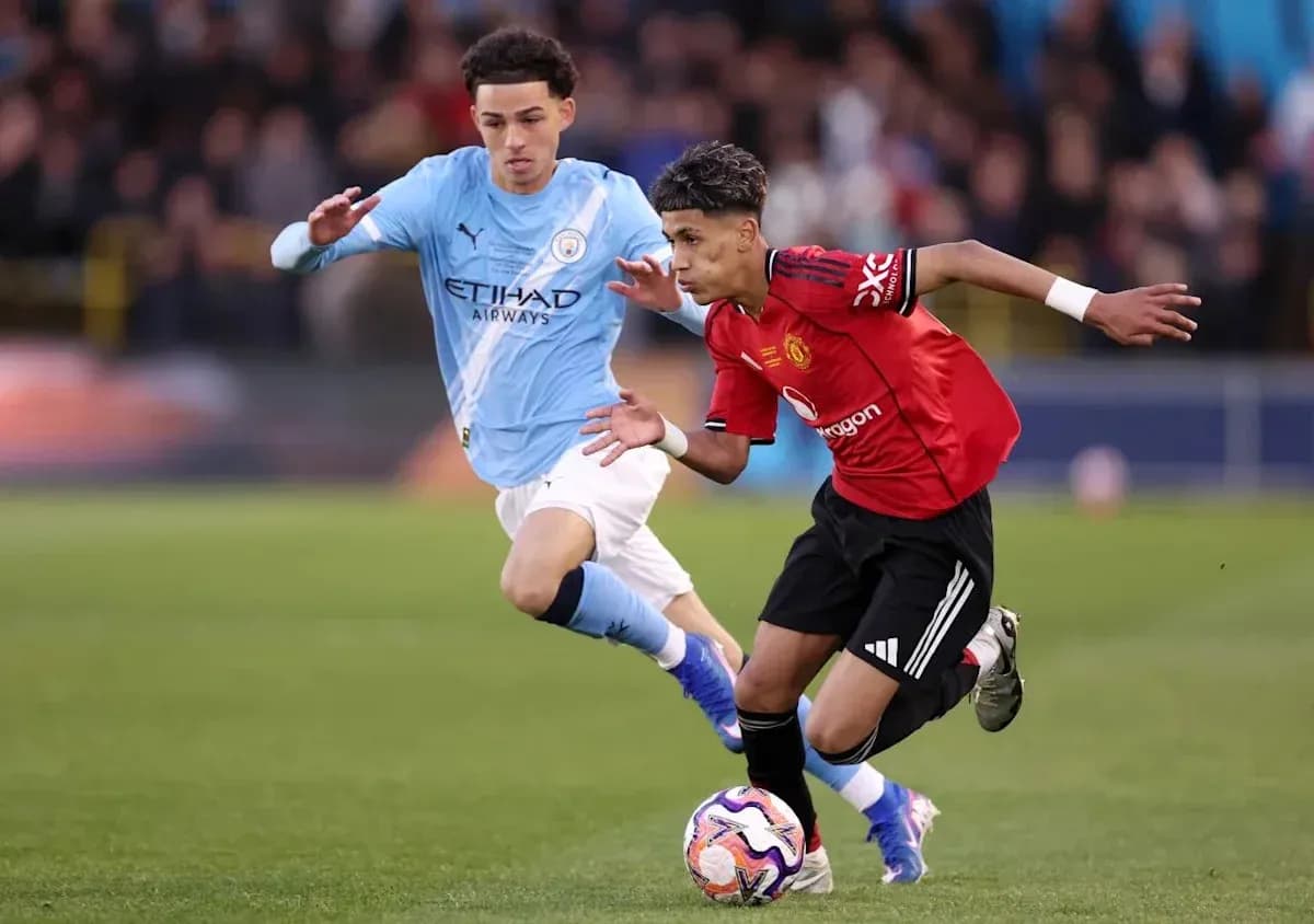 Joueur de Manchester United dribblant un adversaire de Manchester City