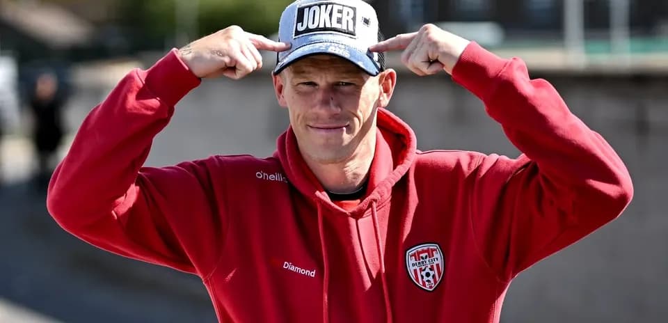 Homme en sweat rouge portant une casquette 'JOKER'