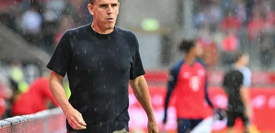 Entraîneur marchant sous la pluie sur le terrain
