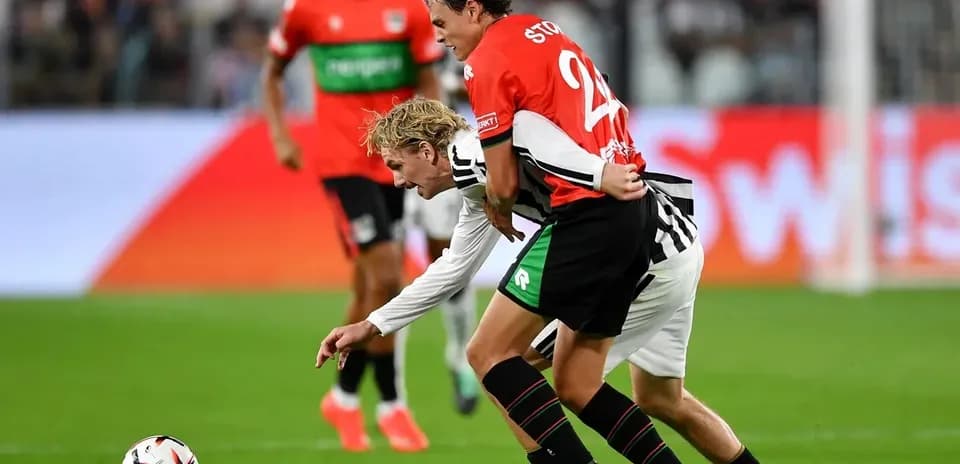 Deux joueurs en lutte pour le ballon sur le terrain