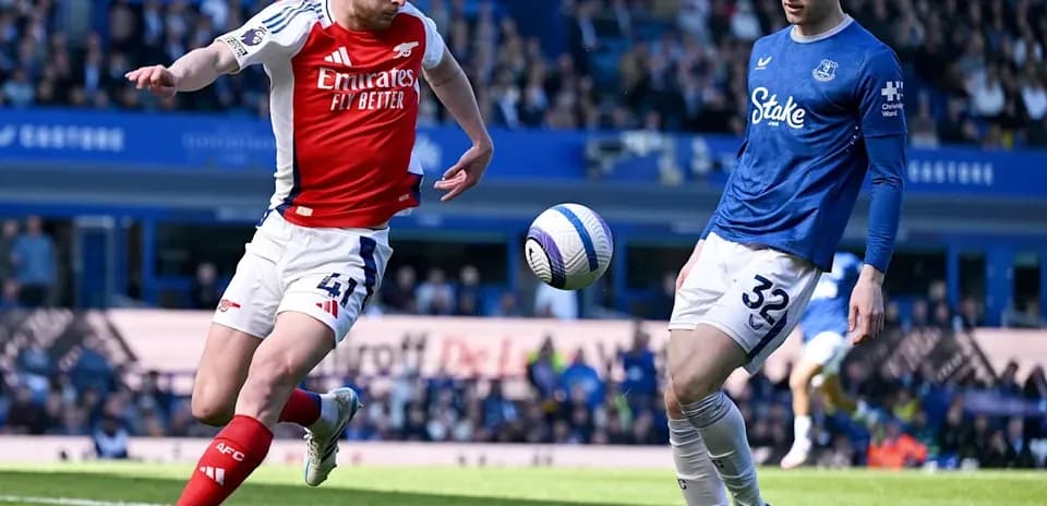 Un joueur d'Arsenal frappe le ballon contre un joueur d'Everton