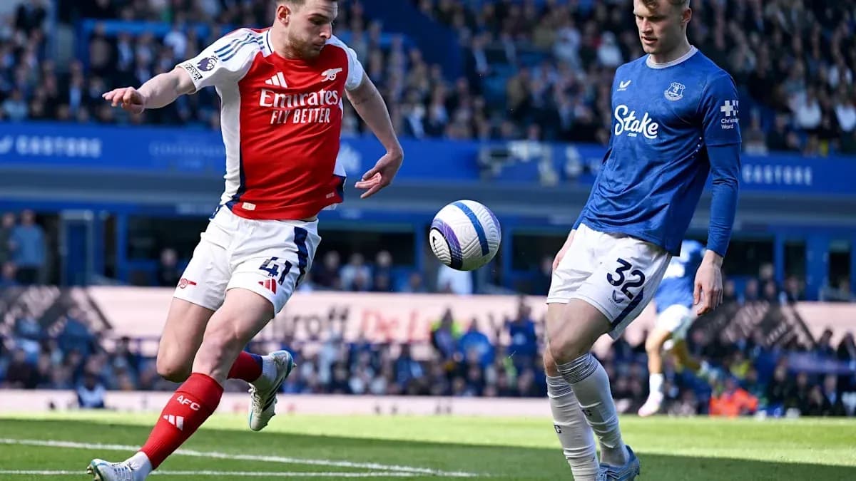 Un joueur d'Arsenal frappe le ballon contre un joueur d'Everton