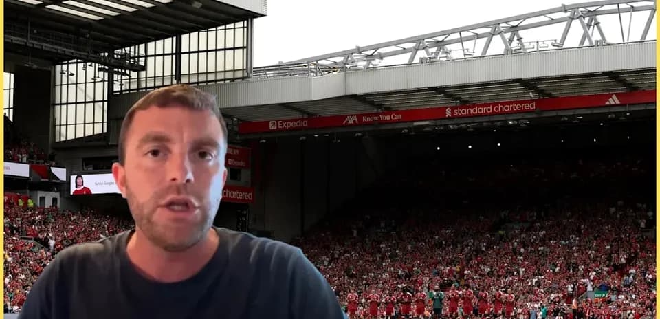 Person speaking in front of Anfield stadium crowd