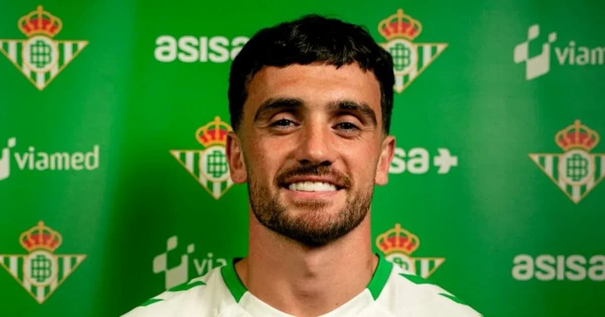 Joueur souriant devant un panneau du Real Betis