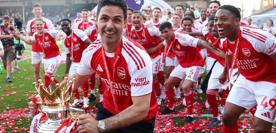 Mikel Arteta celebrating with Arsenal players and trophy