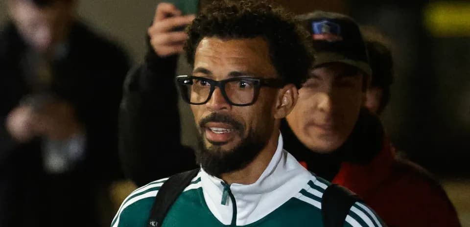 Joueur portant un survêtement vert à l'aéroport