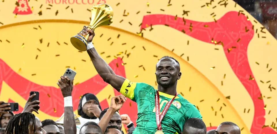 Joueur célébrant avec le trophée de la CAN