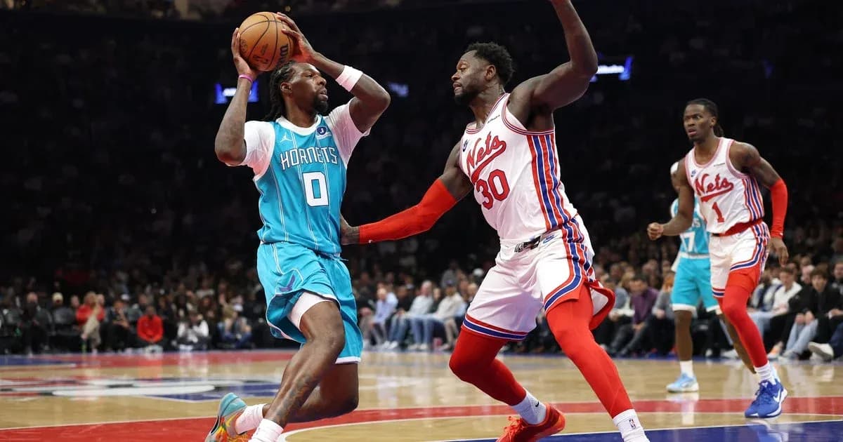 Joueur des Hornets dribblant sous pression des Nets