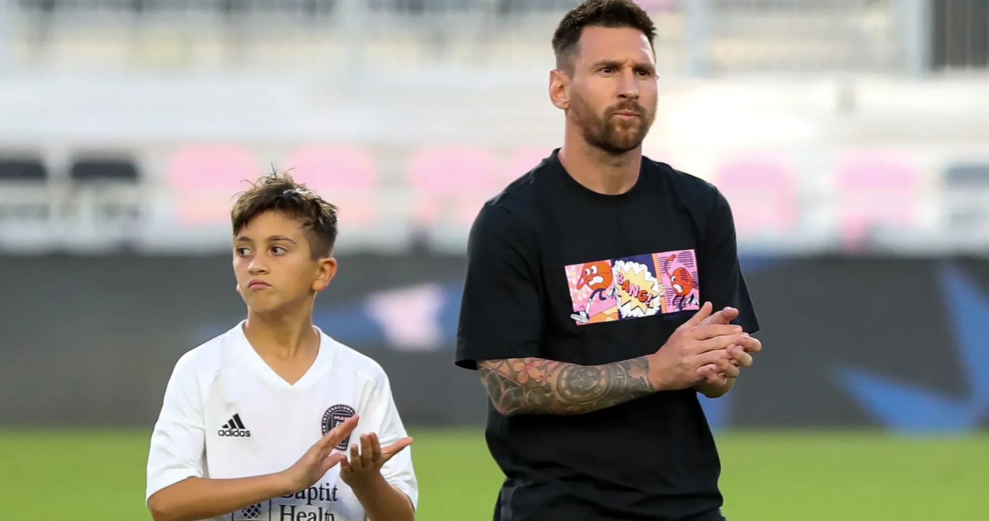 Lionel Messi et un jeune joueur applaudissant sur le terrain