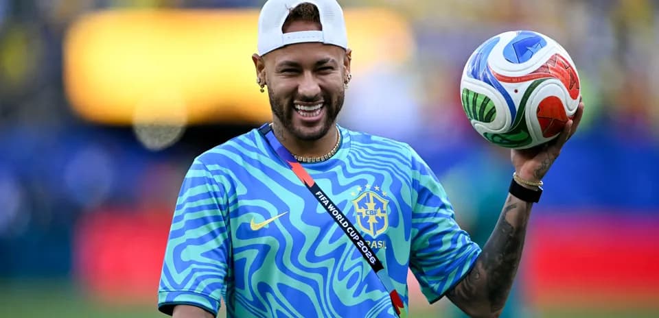 Joueur souriant tenant un ballon de football