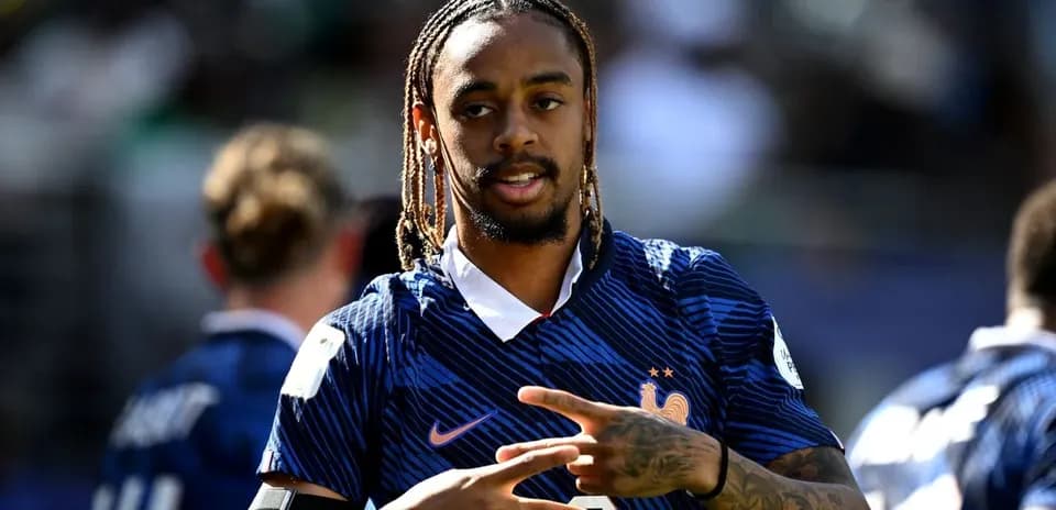 Joueur en maillot de l'équipe de France faisant un signe