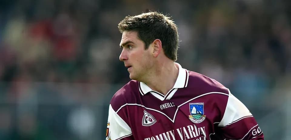 Joueur en maillot maroon courant sur le terrain