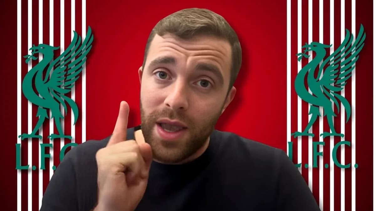 Person speaking in front of Liverpool FC logo