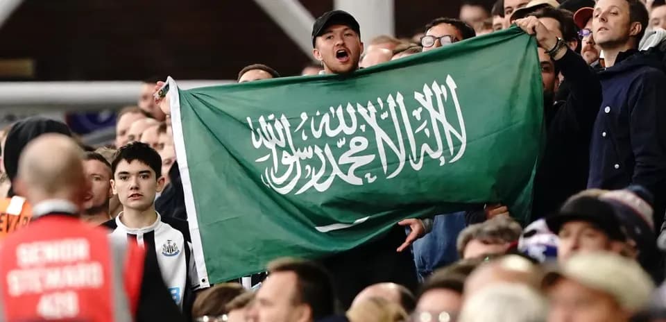 Supporters holding Saudi Arabian flag in the stands