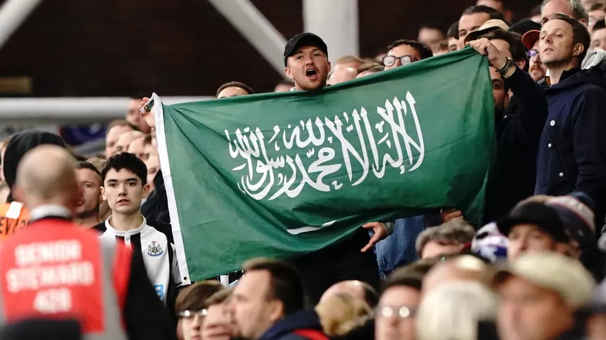 Supporters holding Saudi Arabian flag in the stands