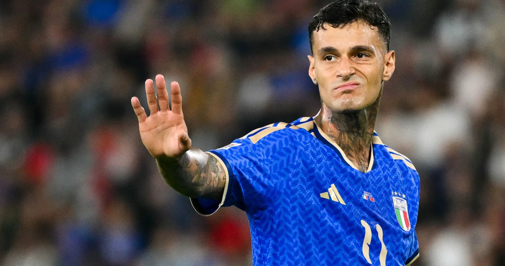 Joueur en maillot bleu d'Italie levant la main