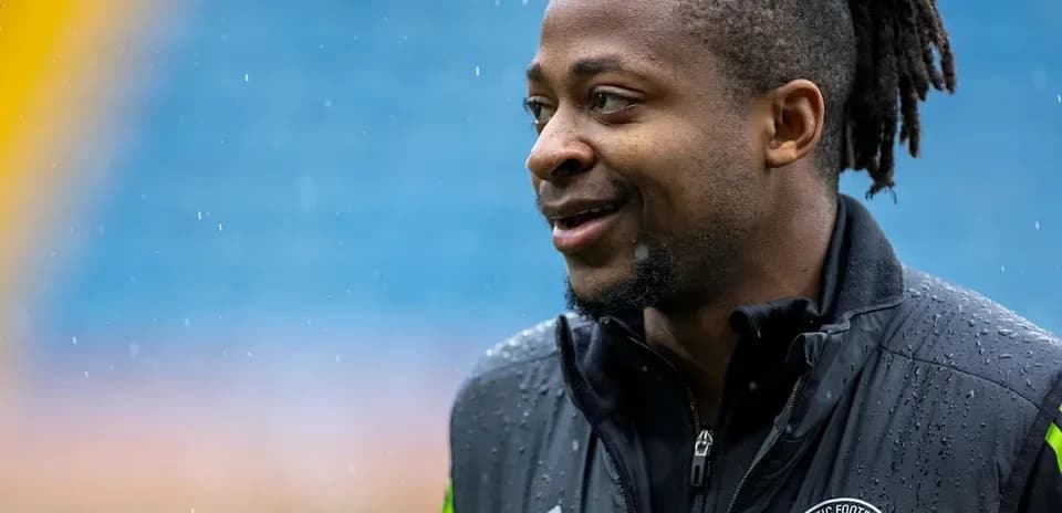 Joueur de football souriant sous la pluie