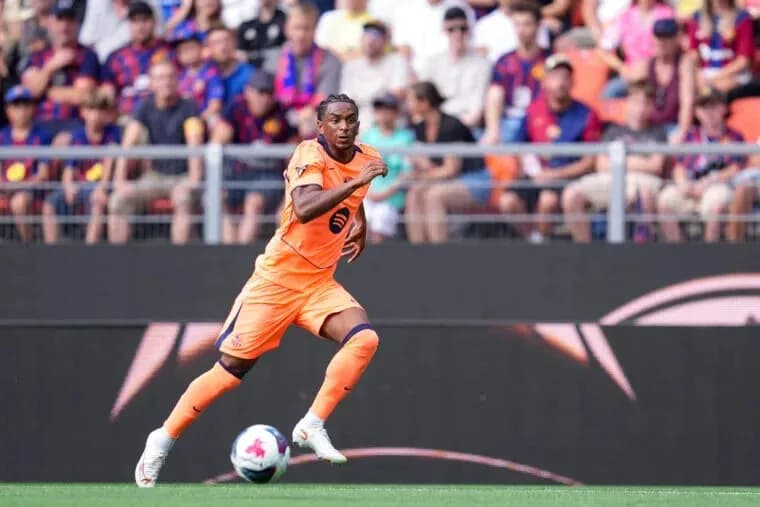 Joueur en orange courant sur le terrain de football