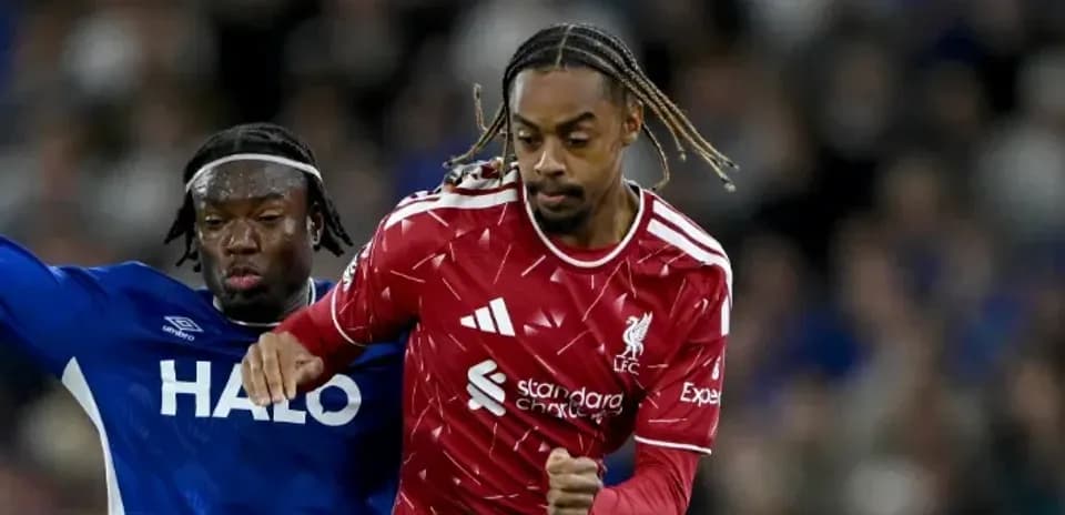 Joueur de Liverpool dribblant un adversaire en bleu