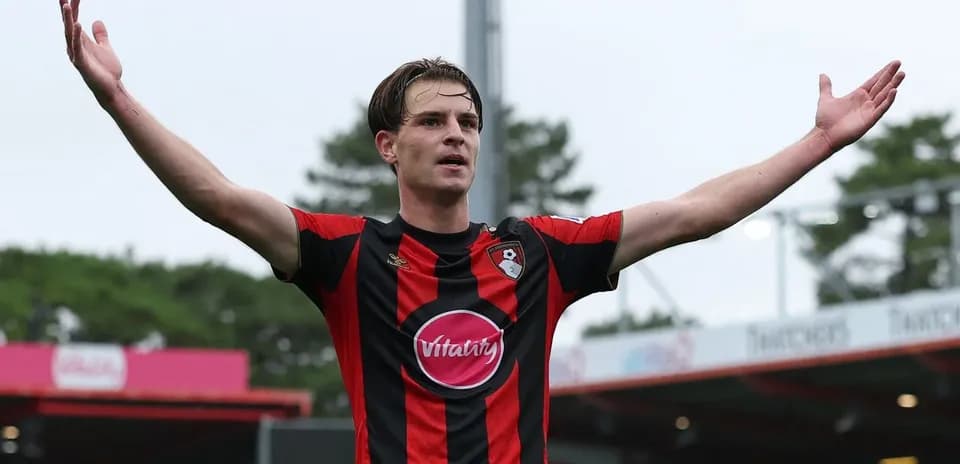 Joueur de Bournemouth levant les bras sur le terrain