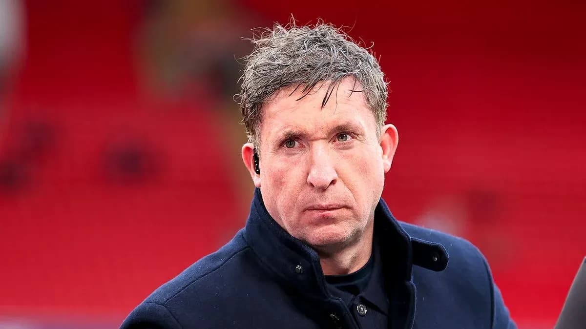 Homme en manteau noir devant un fond rouge