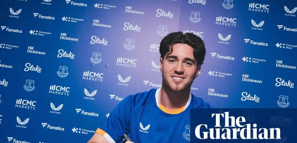 Joueur d'Everton signant un contrat devant des logos