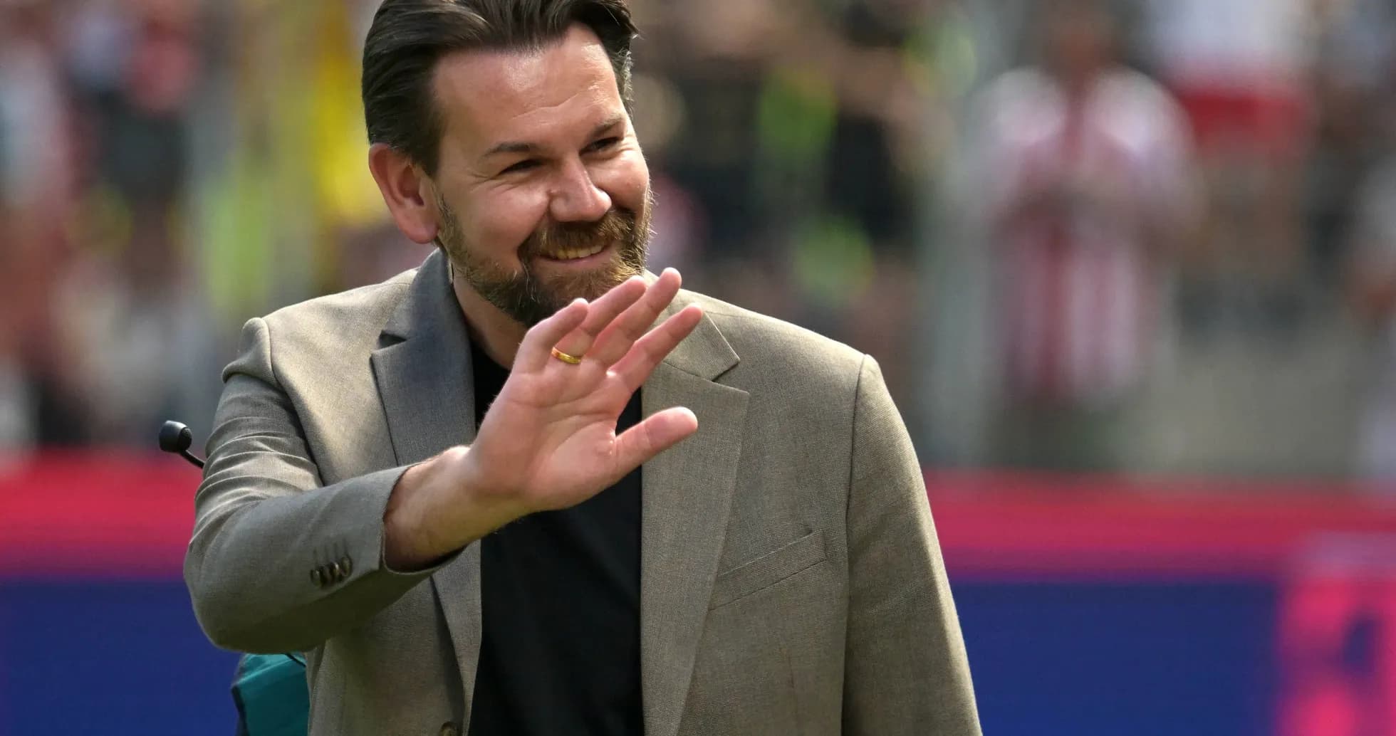 Homme saluant le public dans un stade