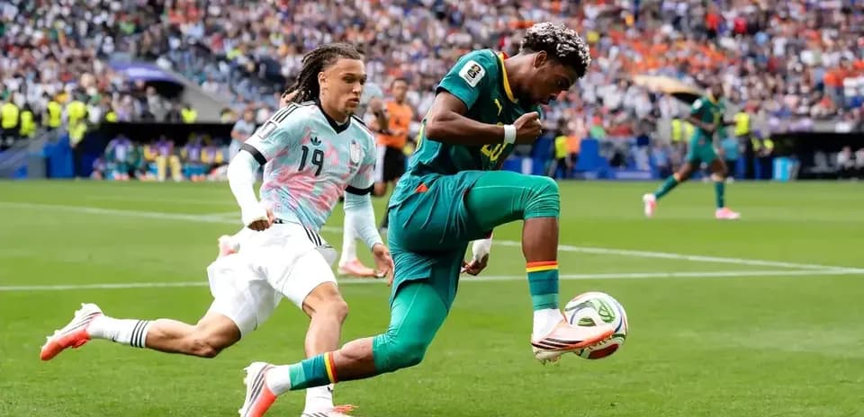 Joueur camérounais dribblant un adversaire lors du match
