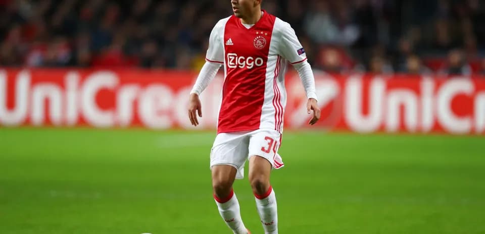 Joueur d'Ajax dribblant sur le terrain de football