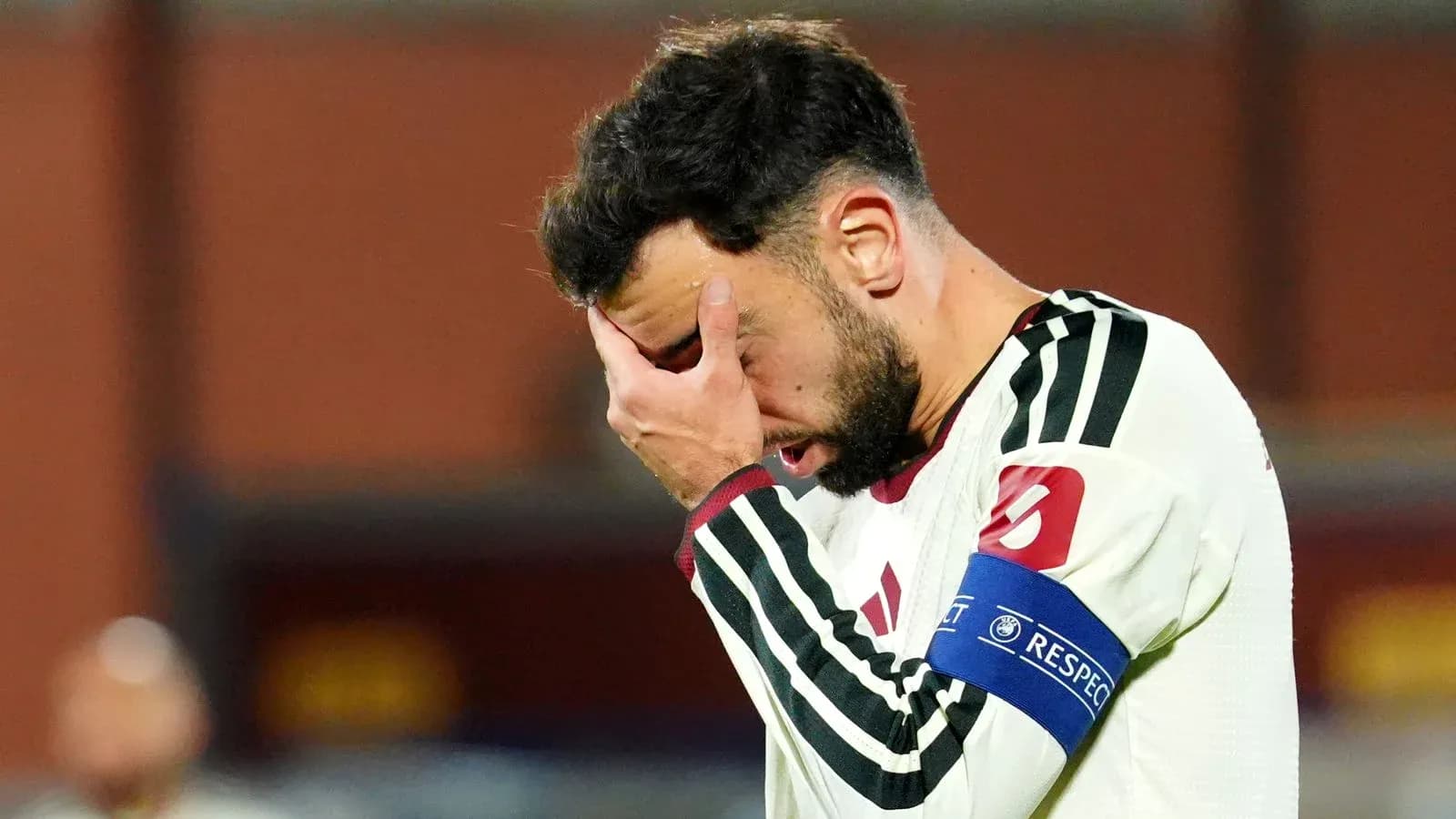 Joueur tenant son visage après un match