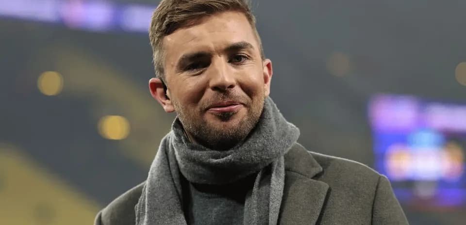 Homme souriant avec écharpe dans un stade