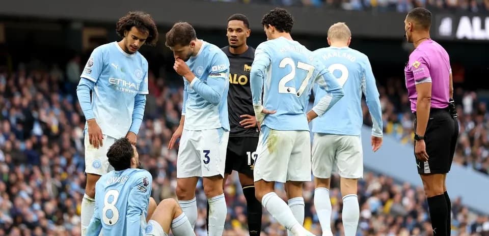 Joueurs de Manchester City entourant un coéquipier blessé