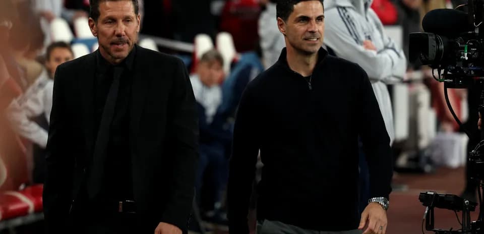 Deux entraîneurs marchant sur le bord du terrain