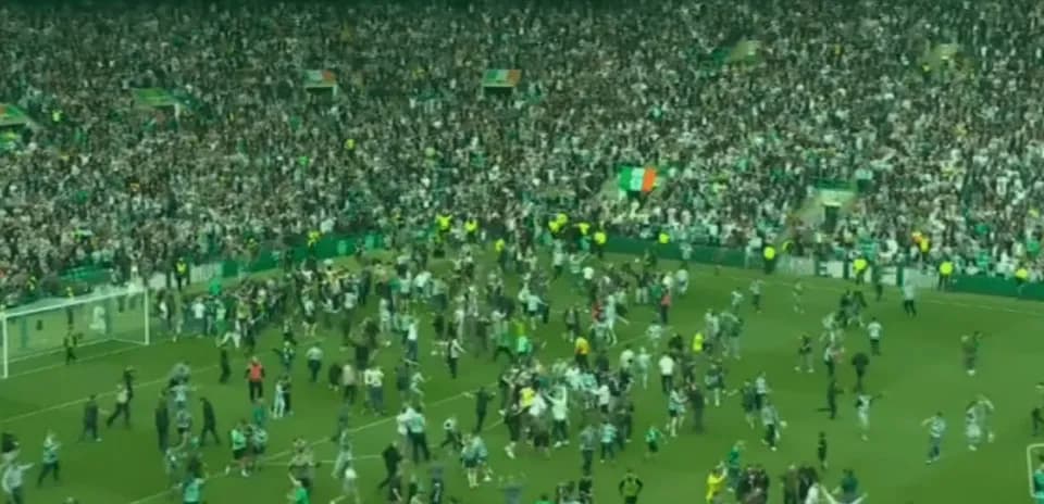 Supporters celebrating on the pitch after match
