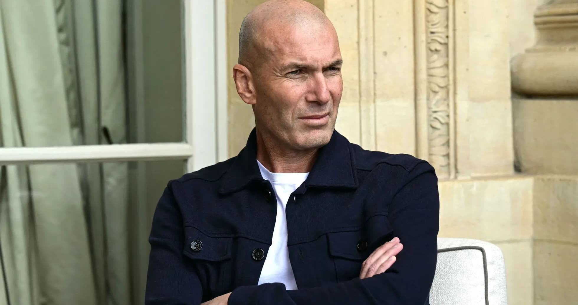 Homme assis avec les bras croisés, regard pensif